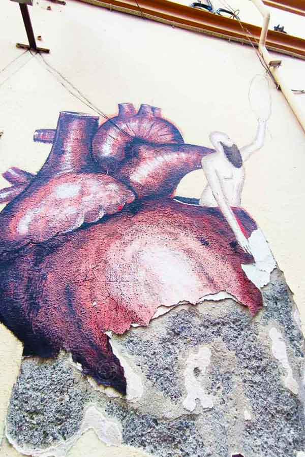 Street art of a broken heart on a decaying wall in Malaga
